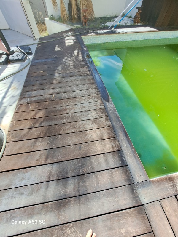 Application d'un traitement de margelle en bois exotique sur une piscine à Lunel