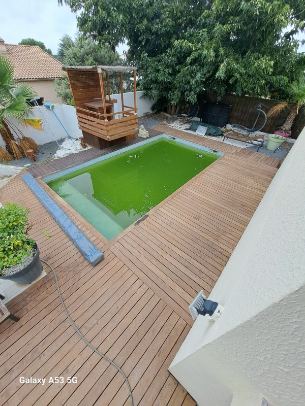 Application d'un traitement de margelle en bois exotique sur une piscine à Lunel