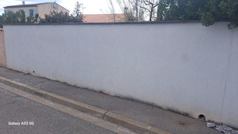 Peintre pour le mur de clôture avec une monocouche avec traitement hydrofuge à Pérols près de Montpellier