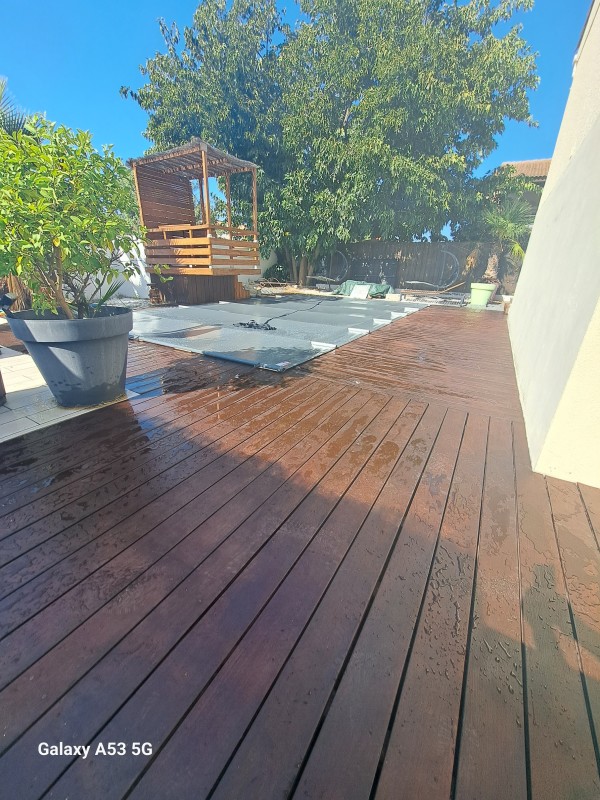 Application d'un traitement de margelle en bois exotique sur une piscine à Lunel
